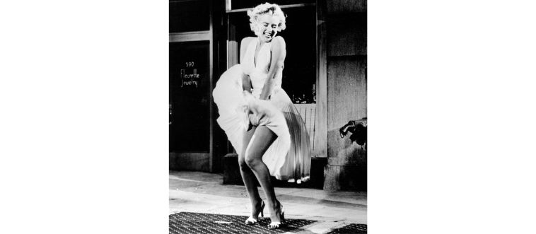 An iconic white halter dress catching a breeze over a subway vent.